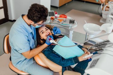 young-female-patient-with-open-mouth-examining-dental-inspection-dentist-office